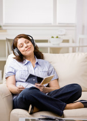 Obraz premium Relaxed woman in headphones enjoying listening to music