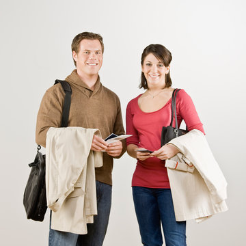 Couple preparing to travel with tickets, coats and briefcase