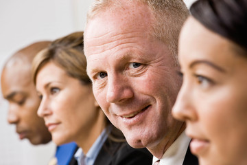 Confident businessman sitting with co-workers