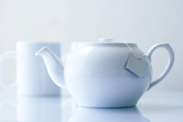 White teapot and cups on the table