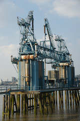 Fototapeta na wymiar Old and rusty industrial pier against blue sky