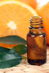 bottle of essential oils and some resh oranges