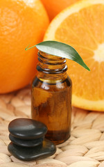 bottle of essential oils and some resh oranges
