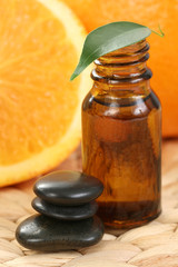 bottle of essential oils and some resh oranges