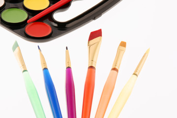 Watercolors palette with paintbrushes isolated on white