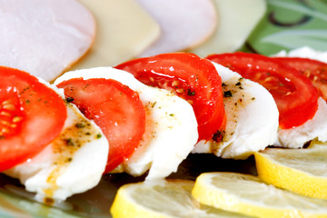 tasty tomato mozzarella salad dish and some salad dressing