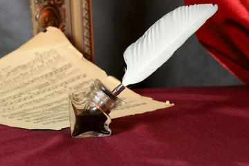 Feather,  ink and a music sheet