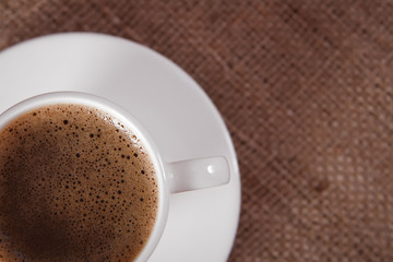 closeup of  black coffee cup on hessian background, shallow DOF