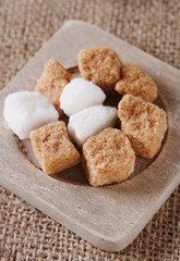 white and brown sugar cubes on old wooden plate