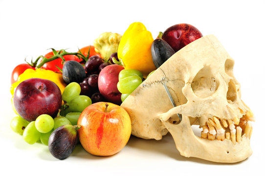 A human skull filled with fruits and vegetables.