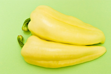 two yellow peppers on green