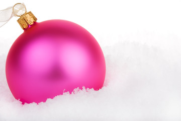 Pink Christmas bauble on snow