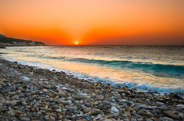 Sunset at Mediterranean beach. Village at Samos Island, Greece.
