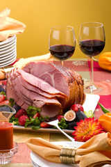 Holiday table setting with delicious whole baked sliced ham