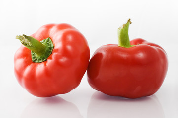 Red bell peppers on white background with reflection