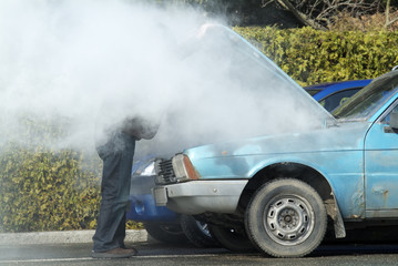 Man looking at a smoking engine in his car - 9770867