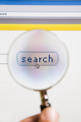 Magnifying glass on top of search icon of computer screen.