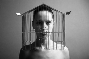Surrealistic portrait of young woman with cage