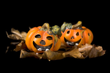 Pumpkins, autumnal leaves ad ghosts on a black