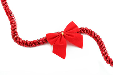 red christmas tinsel and bow on a white background