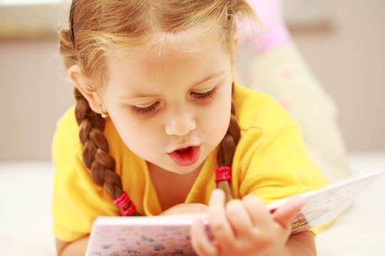 Cute little girl reading a book