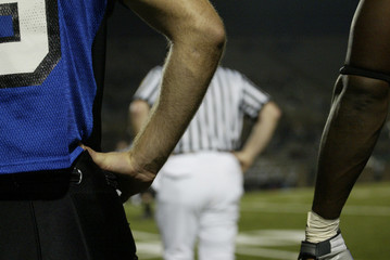 Fototapeta premium Football players at the side line watching the game.