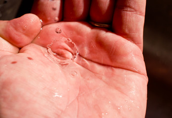 A water drop is caught in the hand.