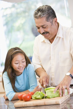 Grandfather And Granddaughter Preparing meal,mealtime Together