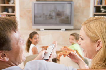 Couple Enjoying Pizza In Front Of TV