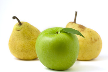 Green apple with leaf in front of two pears