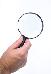A hand holding a magnifying-glass on white background