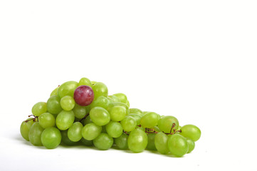 Cluster of white grapes with an outstanding red bean - close up