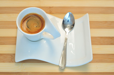 Close up, white cup of coffee and wooden background