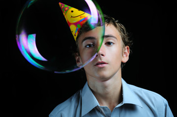 Young boy looking through soap bubbles