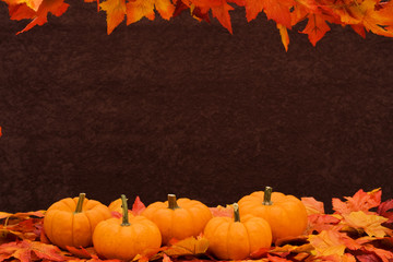 Naklejka na ściany i meble Fall leaves with pumpkin on brown background, fall harvest