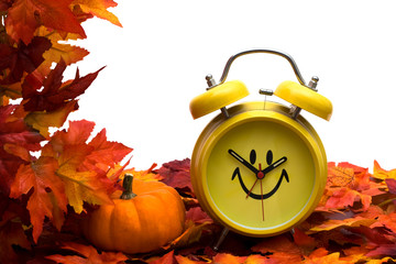 Fall leaves with yellow clock and pumpkin, fall back time change