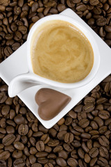 Cup of creamy espresso coffee with chocolate candy