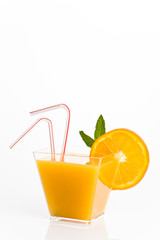 glass of orange juice with straw and mint leaves