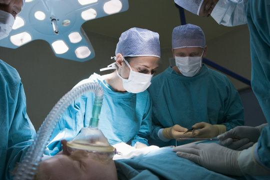 Two Surgeons Operating On A Patient