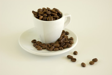 White coffee cup and coffee beans on a light background