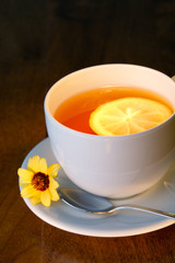 Hot teacup with lemon and flowers.