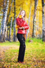 Fototapeta na wymiar Young woman in a park. Autumn season.