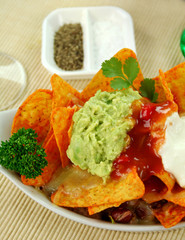 Delicious vegetarian nachos with guacamole and sour cream.