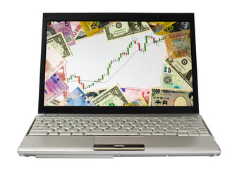 Laptop showing chart of a bull market surrounded by currencies