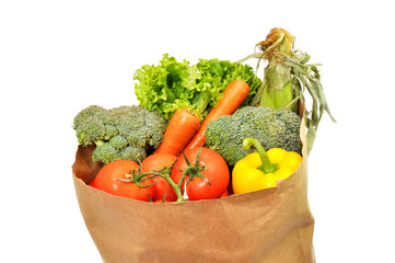 Vegetables in grocery bag isolated on white background.