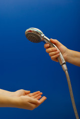 Hand holds a shower on blue background