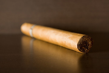 Close up of cigar on dark wooden table