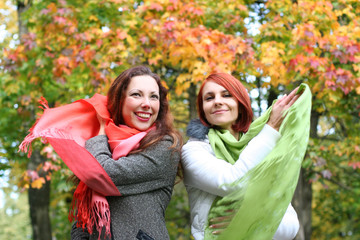 two young girls relaxing in autumn park