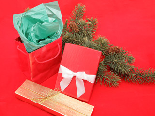Christmas gifts with pine branches on a red background.