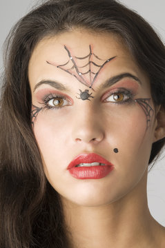 close up of young and nice brunette with spider web painted